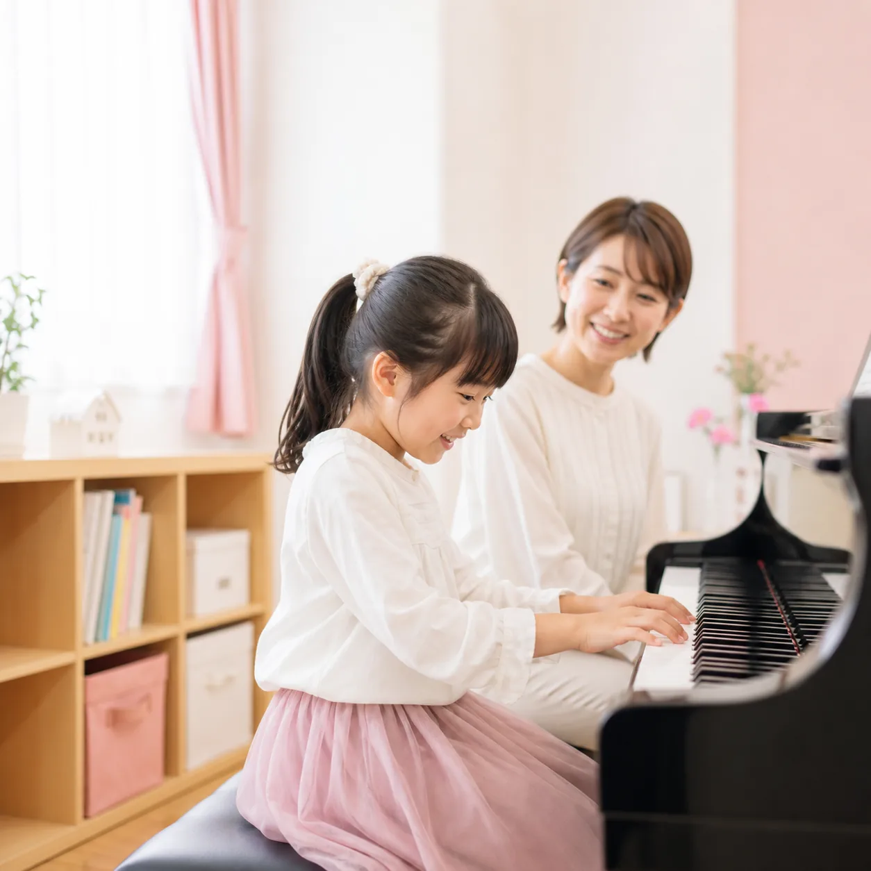 明るい音楽教室で先生と一緒にピアノを楽しむ生徒さんの様子
